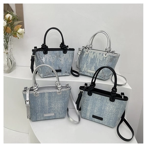 Detailed view of four denim mini tote bags with silver sequins and contrast handles