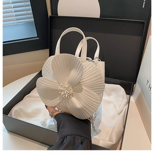 Detailed view of 3D camellia flower petal texture and pearl center on white bucket bag