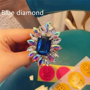Close-up of radiant sunflower phone grip with deep blue gem and iridescent rhinestones