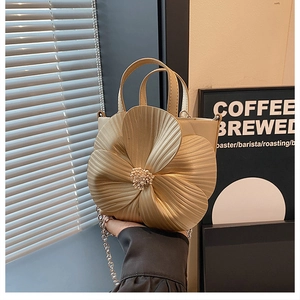 Detailed close-up of champagne bucket bag with 3D floral petals and pearl accents