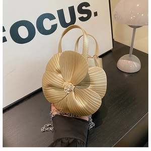 Detail of champagne gold floral bucket bag with petal design and metallic finish