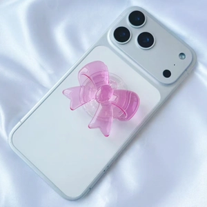 Detailed view of pink translucent bow phone grip with vertical texture on silk background