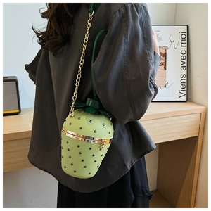 Close-up of strawberry shaped bag with green leaf decor and metallic rivet textures