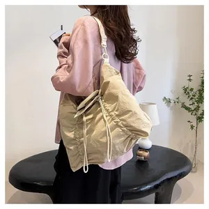 Detail of beige hobo bag showing pleated texture fabric and drawstring closure