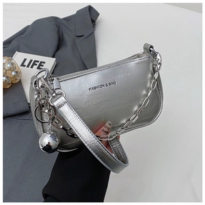 Détail du sac bandoulière argenté métallisé avec bandoulière chaîne et logo mode