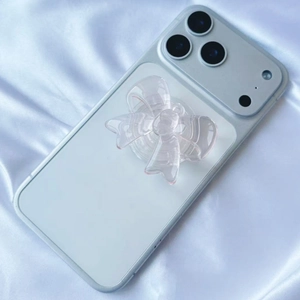 Close-up of a clear resin bow-shaped phone grip on a smartphone with white silk background