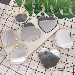 Sparkling diamond-encrusted folding phone grip mirrors in heart and round shapes