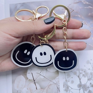 Three-piece smiley acrylic keychains with gold metal rings and black-white designs