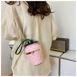Detail of pink strawberry bucket bag with white pearls and gold chain strap