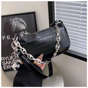 Détail du sac en cuir brillant noir avec chaîne argentée et pendentif sphérique