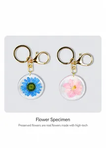 Close-up of gold metal ring and lobster clasp on handmade dried flower resin keychain