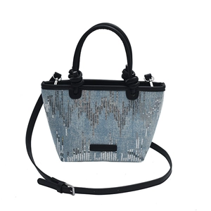 Fashionable blue denim handbag for women featuring silver sequins and black leather straps