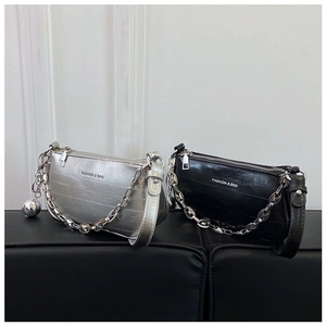Détail des sacs baguette argent et noir avec chaînes en métal et pendentifs sphériques