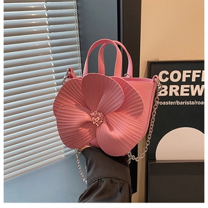 Detail of pink camellia bucket bag featuring 3D petal textures and pearl center