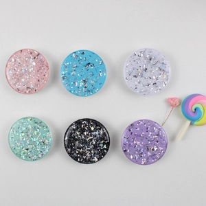 Close-up of six colorful glitter liquid phone sockets with star and moon sequins decoration