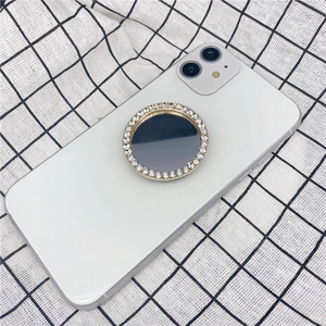 Support de téléphone doré avec strass et miroir fixé sur un smartphone blanc élégant