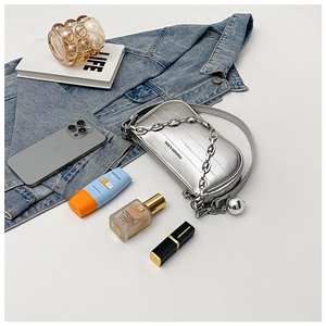 Vue détaillée de dessus d'un sac bandoulière argenté avec chaîne et pendentif tendance