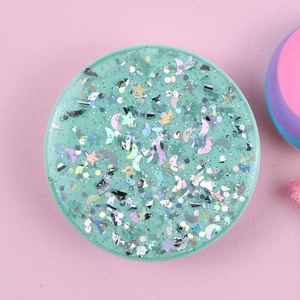 Macro detail of mint green glitter phone socket with shimmering star and moon sequins