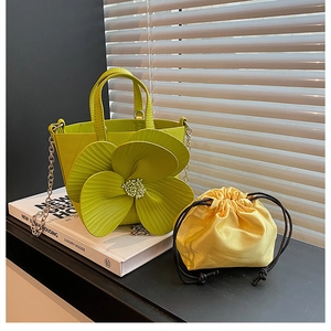 Detail of lime green bucket bag with 3D floral petals and yellow drawstring lining
