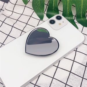 Close-up of heart-shaped makeup mirror phone grip on white smartphone with black trim