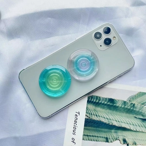 Close-up of circular gradient collapsible phone grips in teal and purple on a smartphone