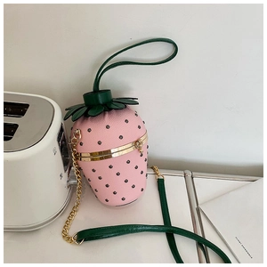 Macro detail of a pink strawberry-shaped crossbody bag with a textured lychee finish