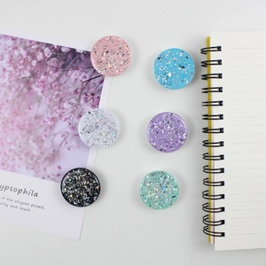 Detail of round glitter phone grips featuring laser star sequins and moon flakes in six colors
