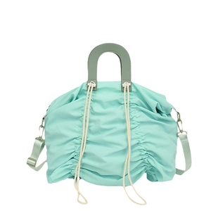 Minimalist mint green pleated canvas tote with top handle and adjustable shoulder strap