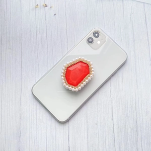 Detail of red marble resin gem phone socket with pearl and rhinestone embellishments