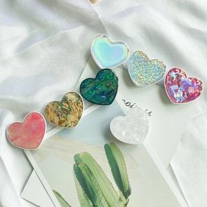 Detailed close-up of heart-shaped phone grips in colorful shells and marble textures
