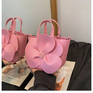 Close-up of pink bucket bag with 3D flower petals and pearl beaded center detailing