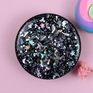 Detail of a sparkling black heart phone grip with silver moon and star glitter