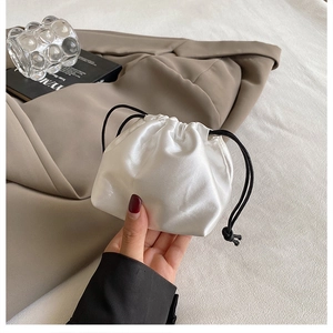 Detail of elegant white satin drawstring bucket bag with premium pearl luster finish