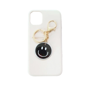 White iPhone case with black smiley face charm and gold metal keychain hook