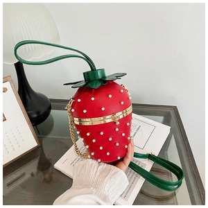 Close-up of strawberry-shaped crossbody bag with red leather and pearl rivet details