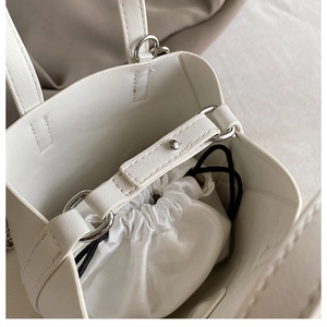 Detail view of white bucket bag with a silk drawstring inner liner and silver hardware