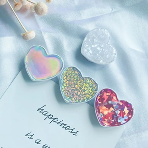 Detail of heart-shaped phone sockets in shell, laser, and glitter finishes on blue silk