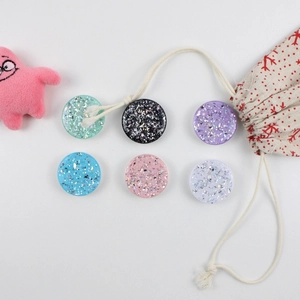 Close-up of circular glitter resin phone sockets in various vibrant sparkling colors