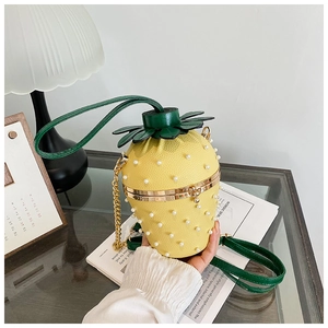 Detail of pineapple bucket bag with pearl embellishments and gold chain strap
