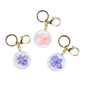Three-piece set of handmade resin keychains with real dried flowers and gold metal ring