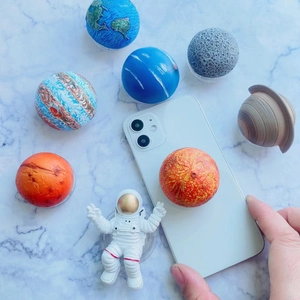 Macro view of cartoon astronaut and colorful planet-themed 3D resin phone grip set