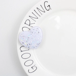 Close-up of heart-shaped glitter phone grip in lavender with holographic sparkles