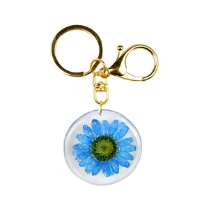 Blue dried flower resin keychain with gold metal hardware and sparkling glitter