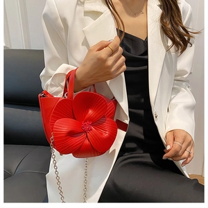Detail of red 3D flower bucket bag with beaded stamens and silver chain strap