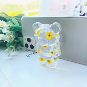 Detail der transparenten Bären-Handyhalterung mit echten gelben Trockenblumen