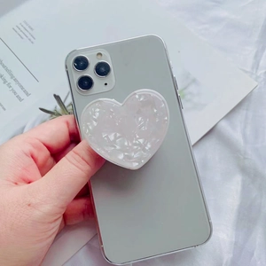 Macro view of heart-shaped pearl texture phone socket grip on a smartphone