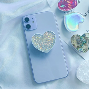 Heart-shaped seashell texture phone grip stand on a light purple smartphone device