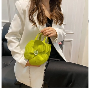 Detailed view of neon green flower-shaped bucket bag with elegant metal chain strap
