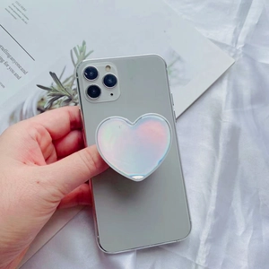 Detailed view of iridescent heart-shaped phone grip on back of smartphone held by hand