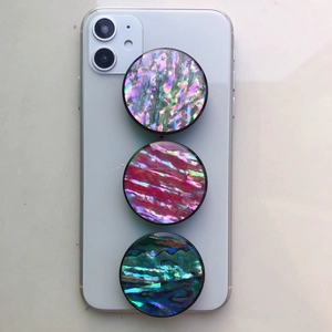 Detail of three expanding phone grips with colorful natural abalone shell texture